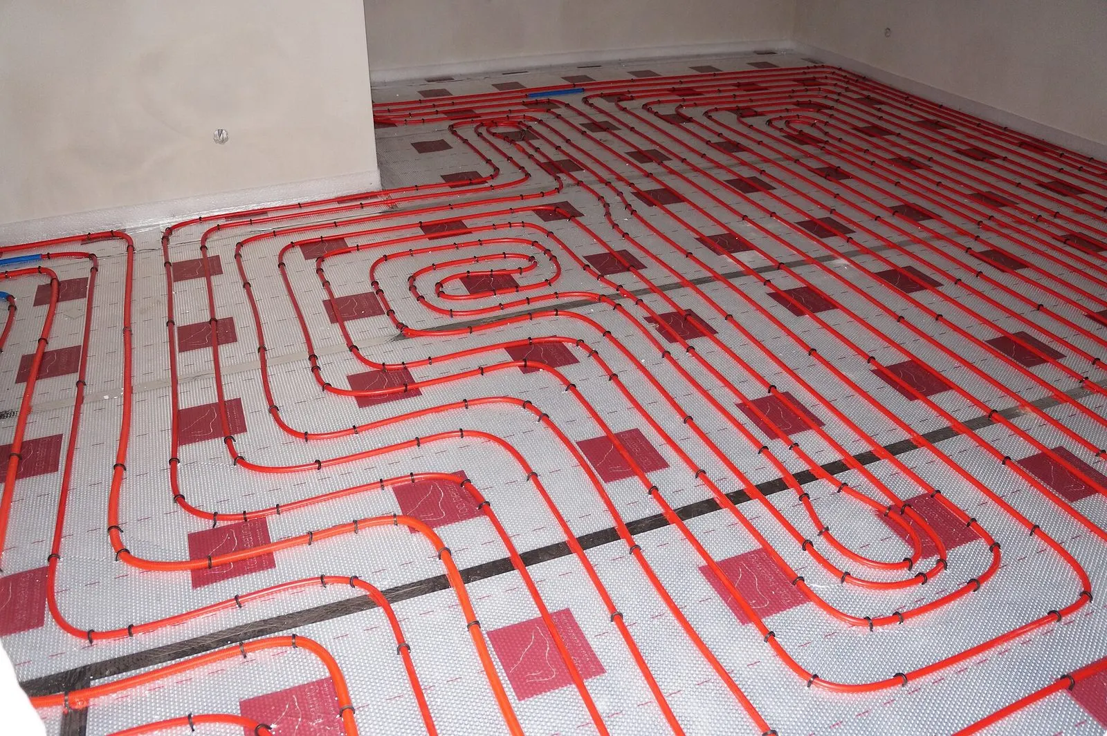 Tubes de plancher chauffant posés sur l'isolant, avant la chape